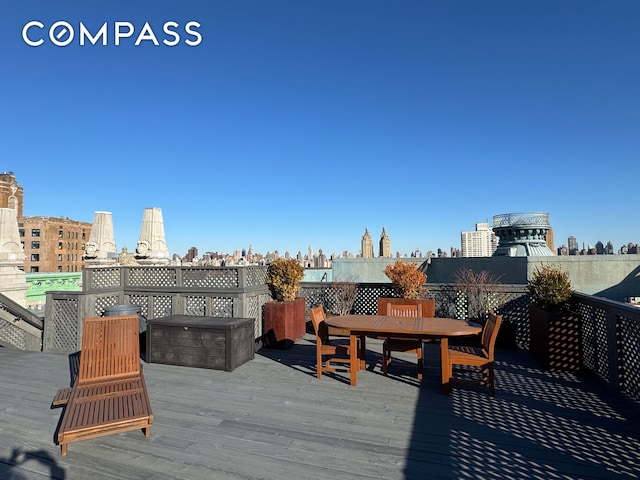 wooden deck with outdoor dining area and a view of city