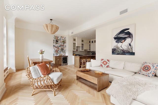 living room featuring a dry bar, beverage cooler, and visible vents