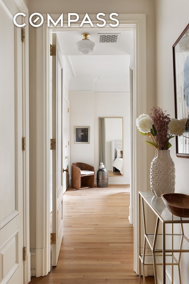 hallway featuring visible vents and wood finished floors