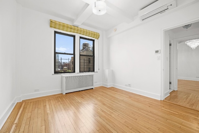 empty room featuring baseboards, radiator heating unit, light wood-style floors, a wall mounted air conditioner, and beamed ceiling