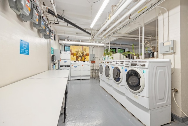 shared laundry area with electric panel and washing machine and dryer