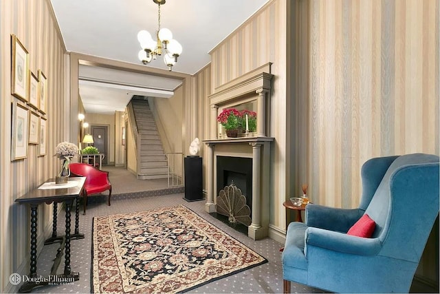 living area featuring a notable chandelier, carpet flooring, stairway, and a fireplace