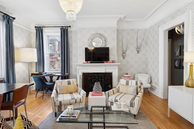 living room featuring a chandelier, wood finished floors, a fireplace, and wallpapered walls