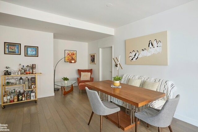 305 E 51st St Unit 7D, New York City, NY 10022 - dining space featuring a bar, wood finished floors, and baseboards