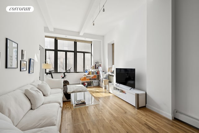 living area featuring a baseboard radiator, beamed ceiling, light wood-style flooring, and visible vents