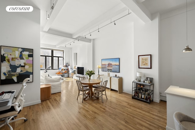 dining room with track lighting, light wood-style flooring, beamed ceiling, and visible vents