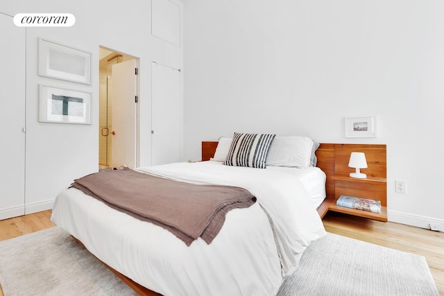 bedroom with visible vents, baseboards, and wood finished floors