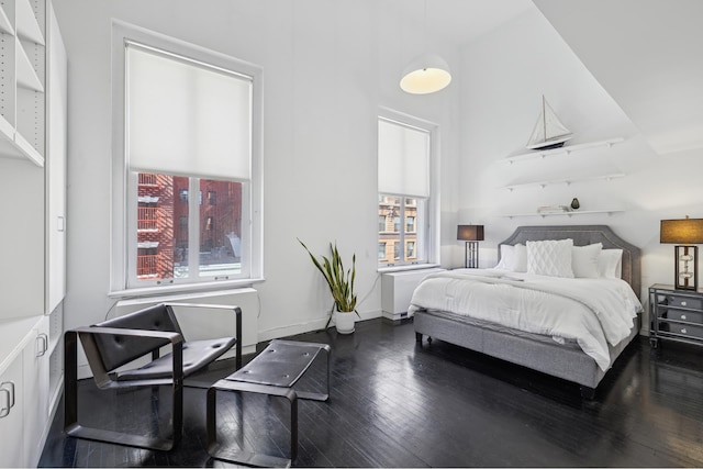 bedroom featuring multiple windows, baseboards, and wood-type flooring