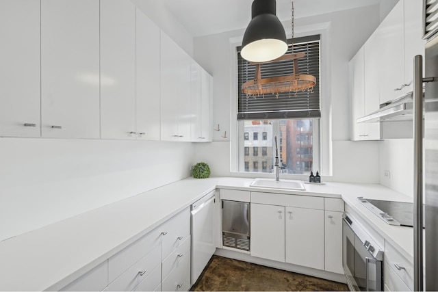 kitchen featuring oven, a sink, white dishwasher, light countertops, and black electric stovetop