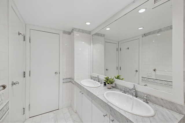 bathroom with a sink, marble finish floor, recessed lighting, and double vanity