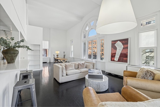 living room with wood finished floors and a towering ceiling