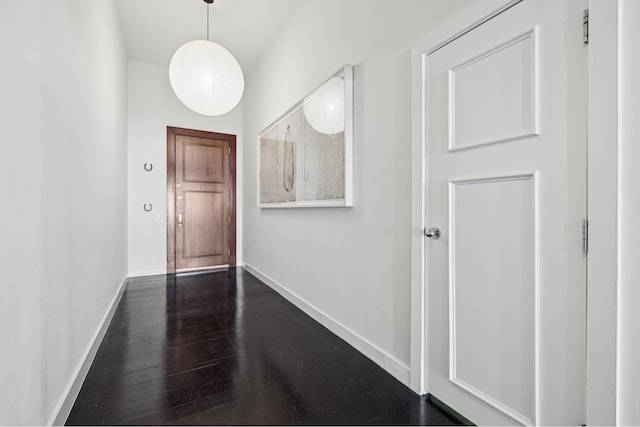 corridor with baseboards and dark wood-style flooring