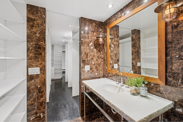 bathroom featuring recessed lighting, a spacious closet, tile walls, and vanity