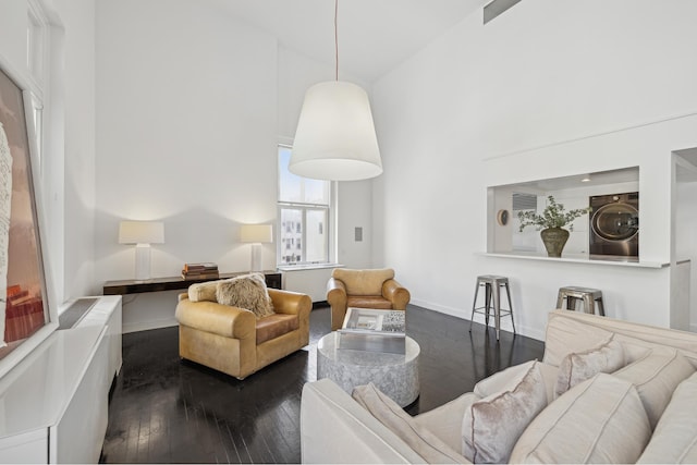 living room with baseboards, wood-type flooring, and high vaulted ceiling