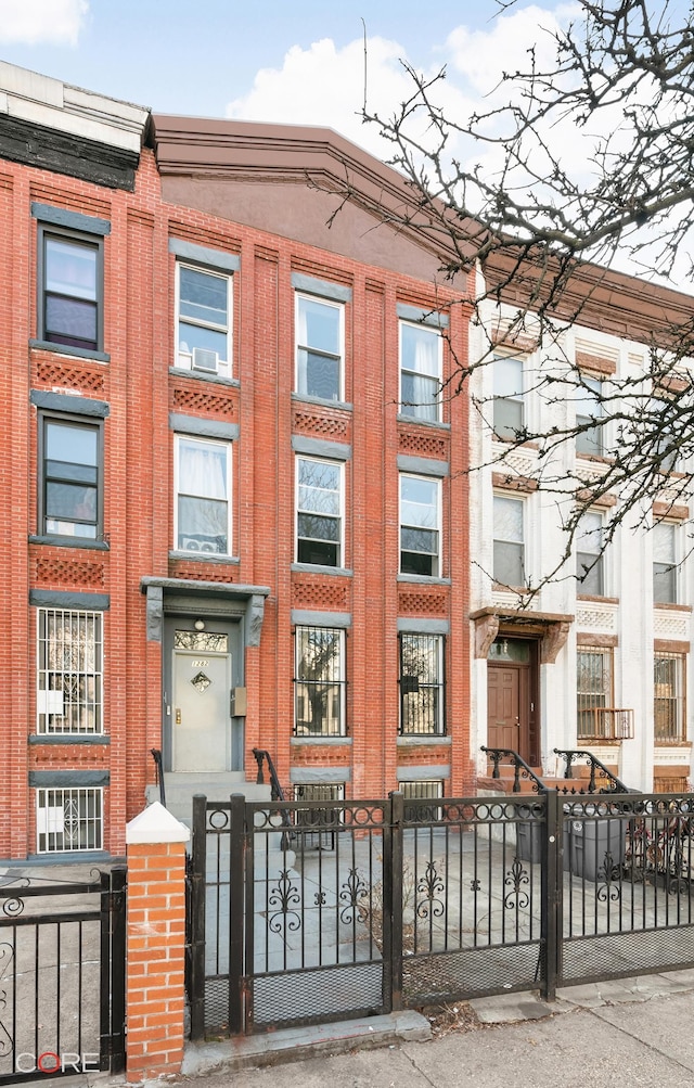 view of front of home with a fenced front yard and brick siding