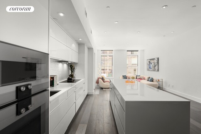 kitchen with modern cabinets, white cabinets, recessed lighting, wood finished floors, and oven