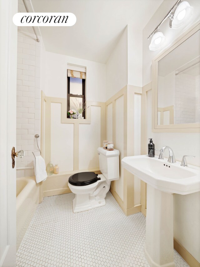 bathroom featuring bathing tub / shower combination, toilet, and a sink