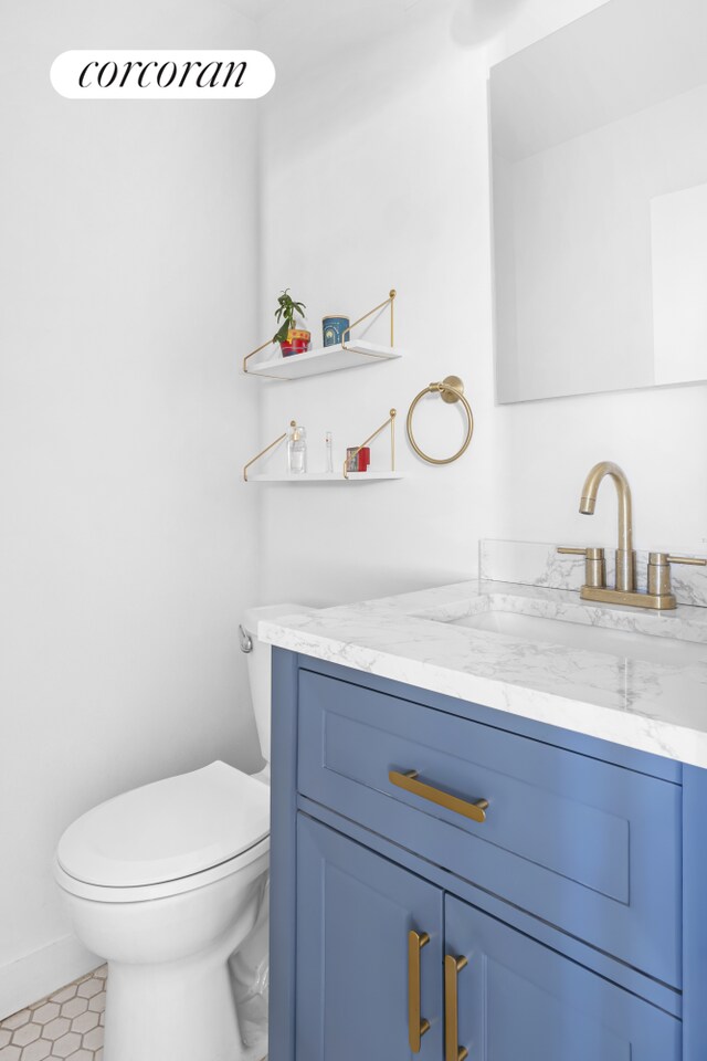 bathroom featuring vanity, toilet, and baseboards