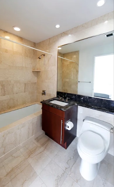 bathroom with recessed lighting, marble finish floor, shower / washtub combination, toilet, and vanity