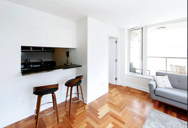 kitchen with baseboards, dark countertops, and a breakfast bar
