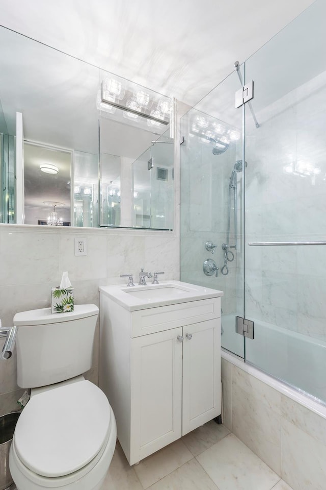 bathroom featuring backsplash, toilet, vanity, tiled shower / bath combo, and tile walls