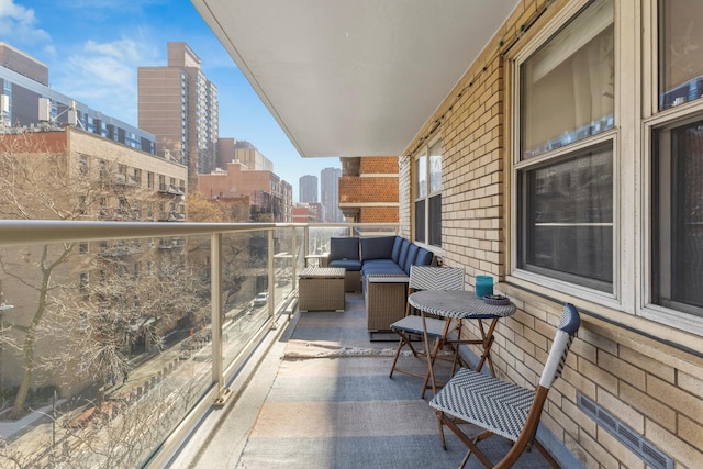 balcony with an outdoor living space and a view of city