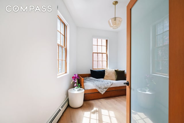 interior space with light wood-style floors and a baseboard heating unit