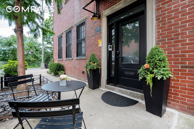 property entrance with covered porch and brick siding