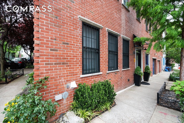 view of property exterior with brick siding and fence