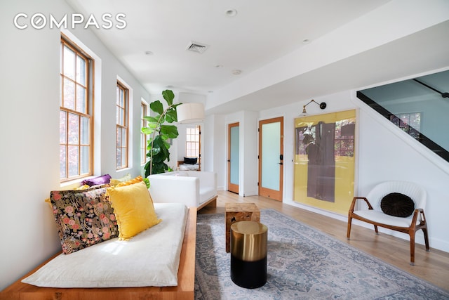 living area with baseboards, visible vents, and light wood finished floors