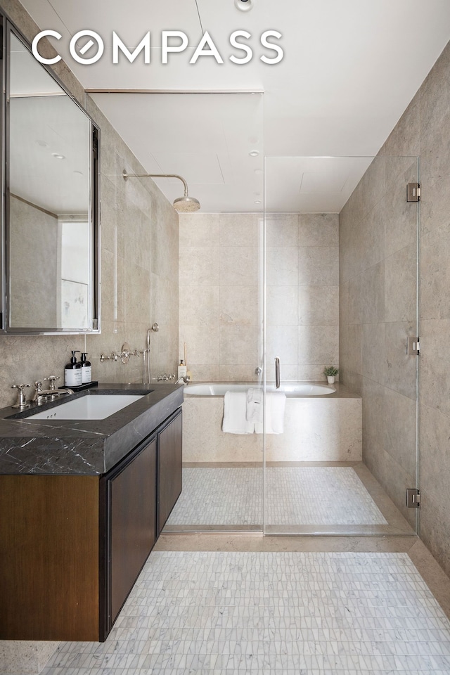 bathroom with a shower stall, vanity, a bathtub, decorative backsplash, and tile walls