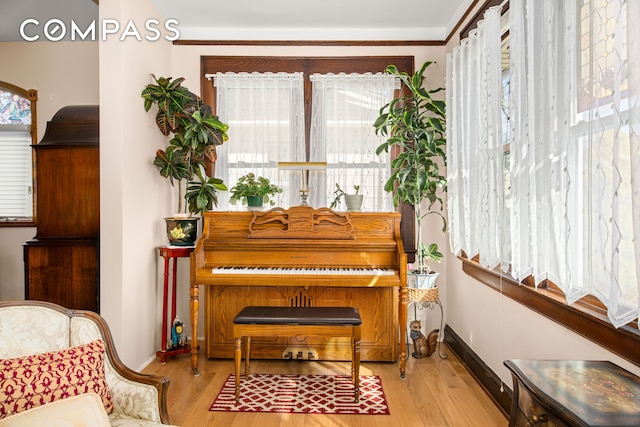 sitting room with plenty of natural light, wood finished floors, and baseboards