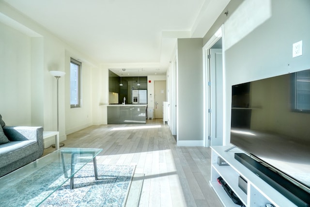 living area featuring light wood finished floors and baseboards