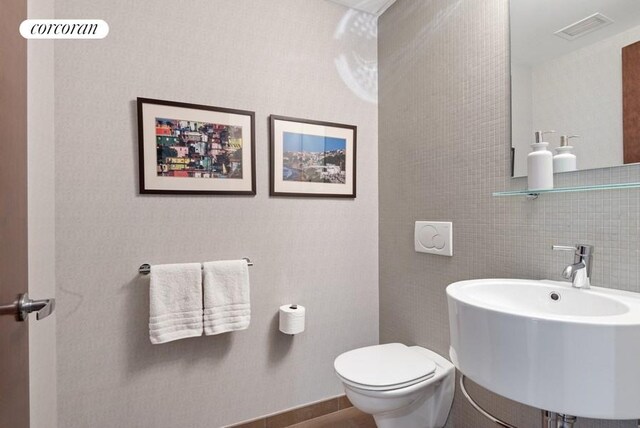 462 W 58th St Unit 1A, New York City, NY 10019 - bathroom featuring visible vents, toilet, and a sink