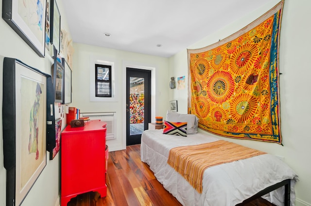bedroom with recessed lighting, access to outside, and wood finished floors
