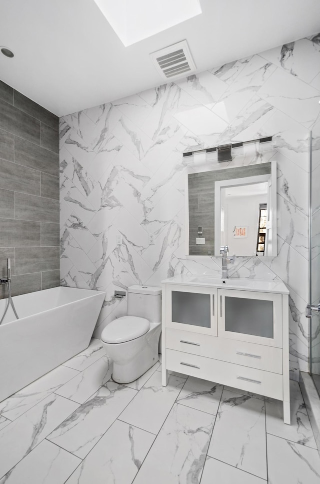bathroom featuring vanity, a soaking tub, toilet, visible vents, and marble finish floor