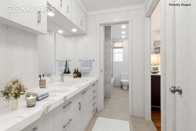 full bath featuring vanity, a tub to relax in, crown molding, toilet, and tile patterned floors