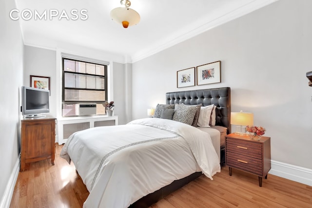 bedroom featuring crown molding, cooling unit, wood finished floors, and baseboards