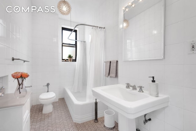 full bath featuring shower / bath combo, a sink, tile walls, toilet, and tile patterned floors