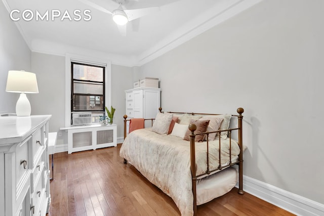 bedroom featuring baseboards, radiator, crown molding, and hardwood / wood-style flooring