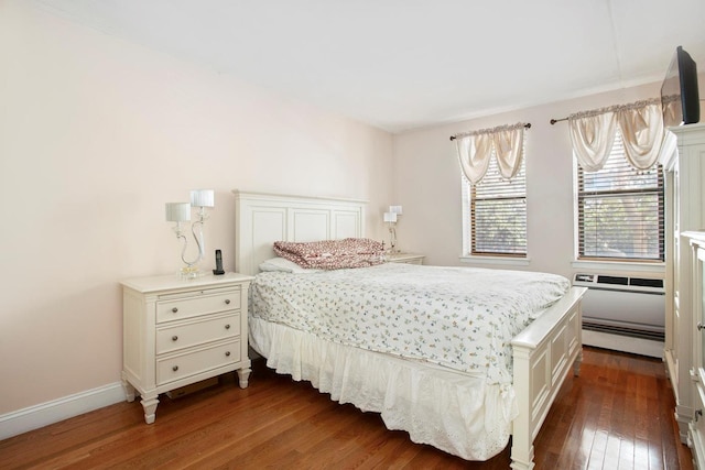 bedroom with baseboards, baseboard heating, and dark wood finished floors