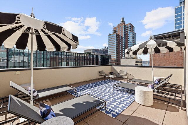 view of patio with a balcony and a view of city