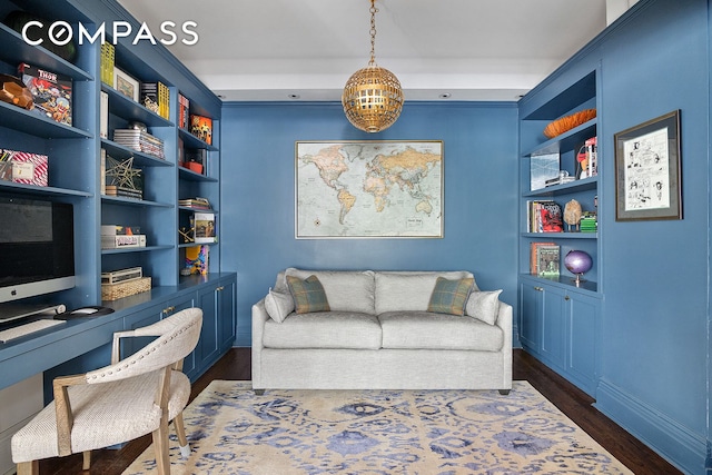 office with baseboards, built in shelves, and dark wood finished floors