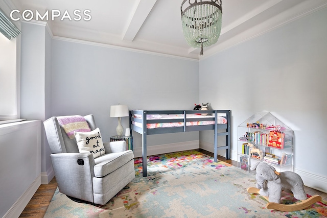 bedroom with beamed ceiling, baseboards, and wood finished floors