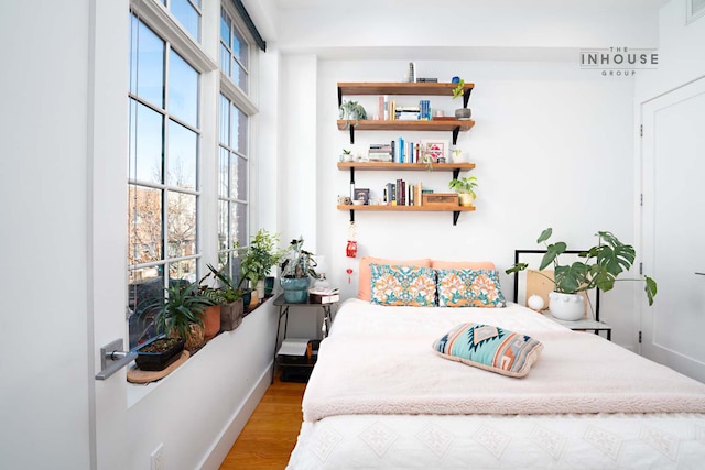 bedroom featuring wood finished floors and baseboards