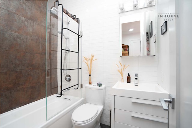 full bathroom featuring vanity, bathtub / shower combination, tile walls, toilet, and tasteful backsplash