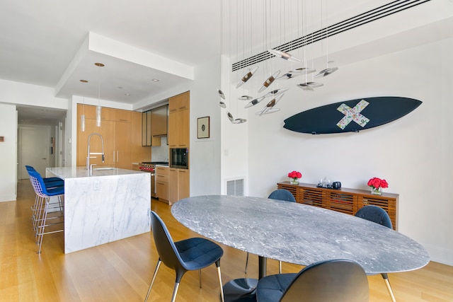 dining room featuring light wood-style flooring and visible vents