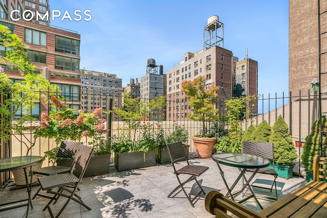 view of patio with outdoor dining area and a view of city