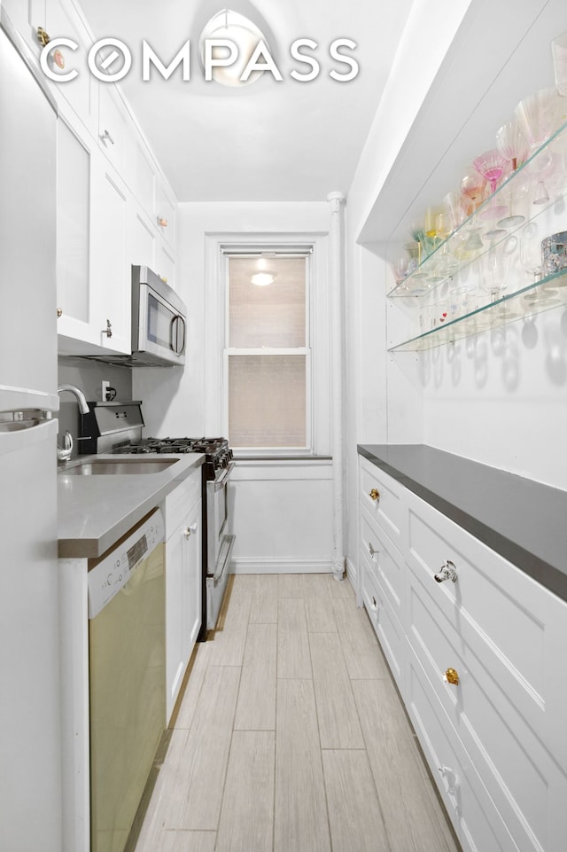 kitchen featuring dark countertops, appliances with stainless steel finishes, and white cabinetry