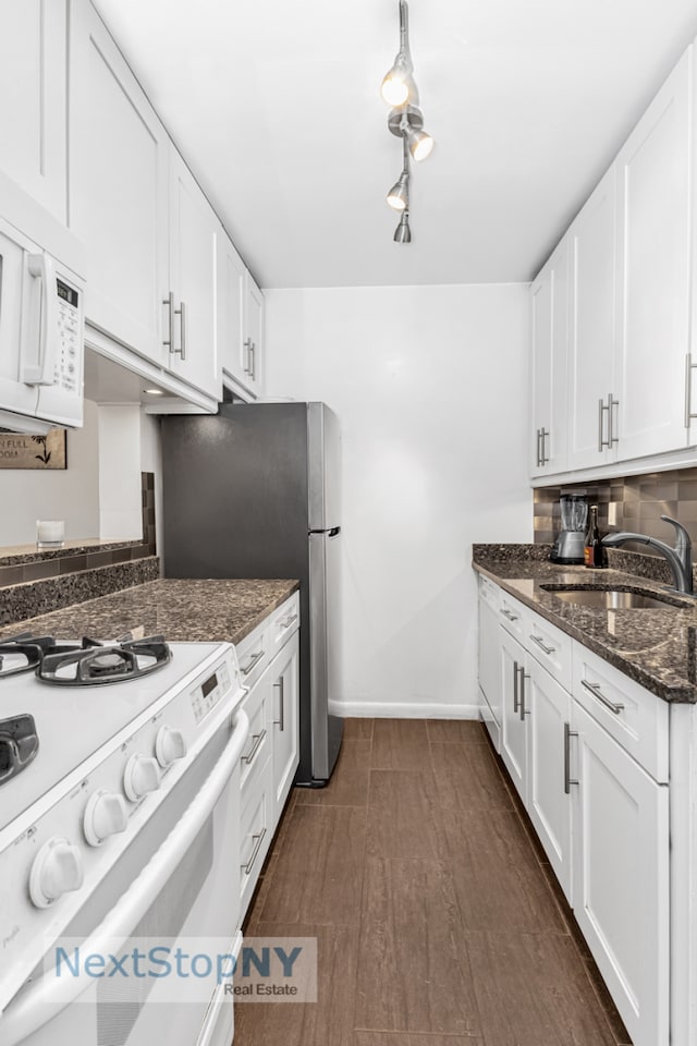 kitchen featuring backsplash, baseboards, white cabinets, white appliances, and a sink